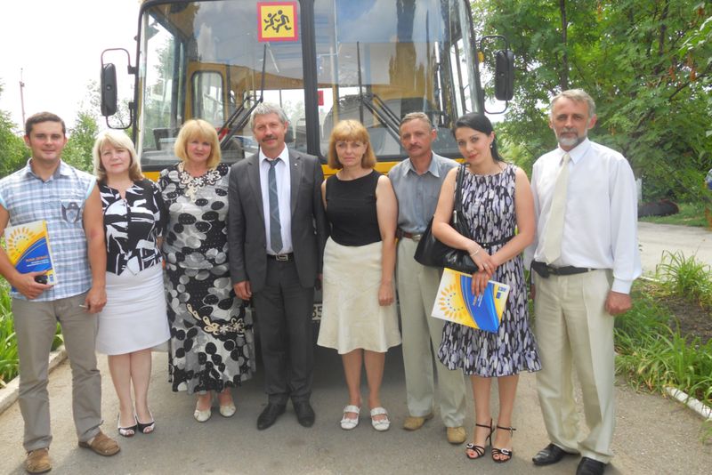 Петро Гончарук разом з лідерами громадської організації «Відродження» на фоні шкільного автобусу – однієї з ініціатив громади
